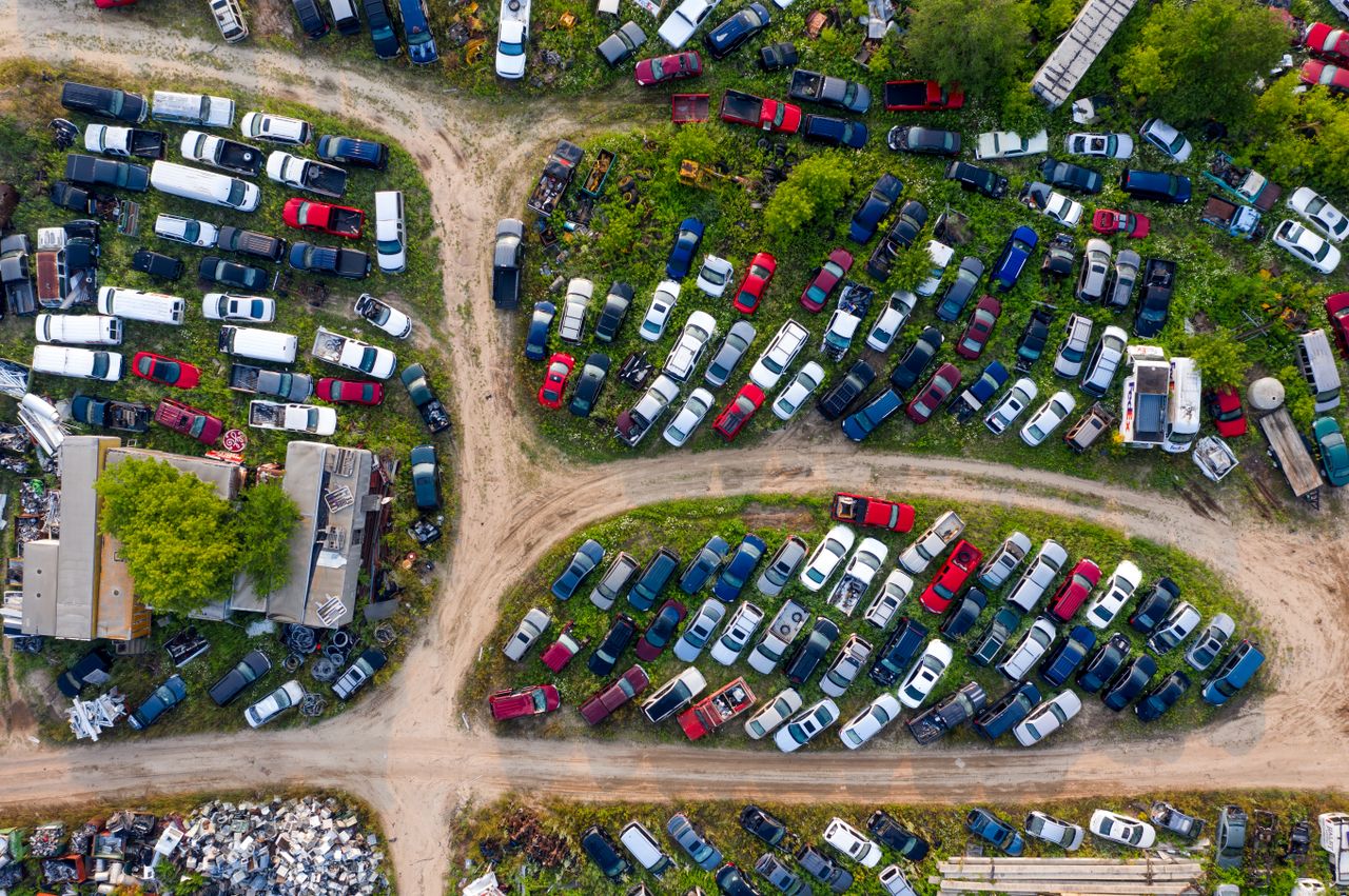 Aerial drone shot of a colorful junkyard filled with abandoned cars in Saint Charles, MN.