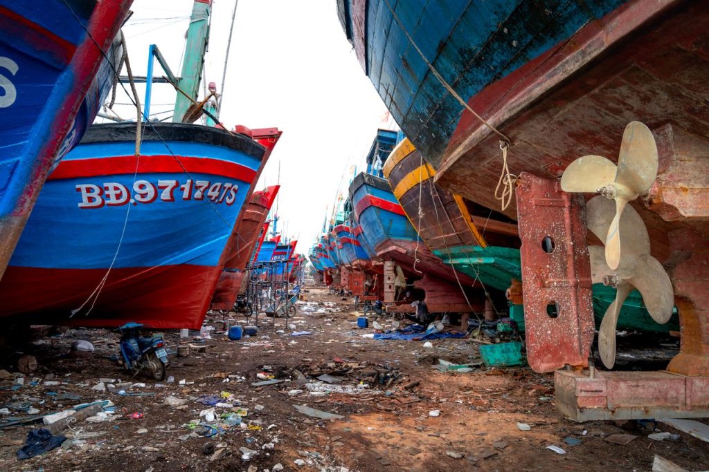 rusty-ships-in-a-dock-13757248 Vibrant fishing boats lined up at a rustic shipyard, showcasing maritime industry and craftsmanship.